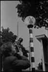 5388 Cineast met Paillard/Bolex-camera filmt een beschilderde- treurende- knipperbol.