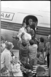 5575-2 Een invalide meisje van de Adriaanstichting wordt op de vliegtuigtrap gedragen.