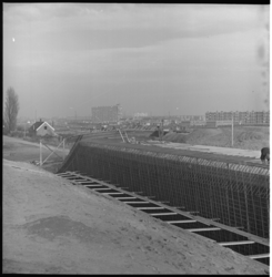 5697-2 Betonijzer tijdens de bouw van spoorviaduct over Groene Kruisweg bij Pendrecht, links staat nog een huisje aan ...