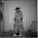 648-2 Mannequin showt kleding, bekeken door een op de grond liggende poes.