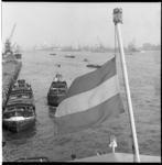 6486 Havengezicht over de Nieuwe Maas met een scheepsvlag halfstok op de voorgrond.
