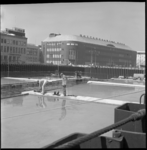6815 Zwemmers op en rond het metrobouwdok op het Churchillplein. Op de achtergrond de gebouwen van het Rotterdamsch ...