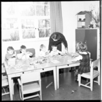 6962 Mejuffrouw J. Pot, leidster van clubhuis 'Het Anker', met kinderen die na schooltijd door haar worden beziggehouden.