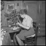 7162 Schilderes Hannie Bouman zit aan tafel, gebruikt een typemachine-achtig apparaat en voert actie voor behoud van de ...