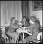 7184 Mejuffrouw C.W. de Werd geeft in een huiskamer kookadviezen aan aspirant huisvrouwen.
