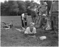 744-2 Deelnemers aan de 'Tour de Verenigde Naties' ontspannen zich op een grasveld..