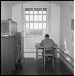 7467-1 Gedetineerde zit aan een tafel in zijn cel in de gevangenis aan de Noordsingel.