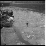 7506 Hulpverleners met een bootje van de reinigingsdienst proberen hondje te redden die bij de Lombardkade tussen de ...