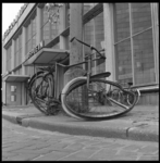 8074 Gesloopte fiets hangt voor de ingang van station Hofplein tegen een paal.
