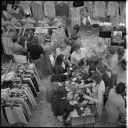 8173-3 Overzicht bovenaf: graaien in de textielbakken tijdens uitverkoop en opruiming in warenhuis Ter Meulen.