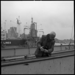 8632-2 Gebarentaal van een havenwerker, in contact met de kraanmachinist, bij het ruim van een schip in de Maashaven.
