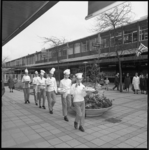 8700 Leerling-bakkers in kokskleding lopen met slagroomtaart in de Lijnbaan, op weg naar restaurant/tearoom Scheffers.