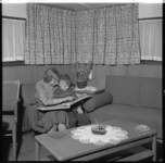 881-3 Vrouw en kind bekijken album in de huiskamer van een binnenvaartschip.
