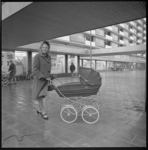 8925-1 Vrouw met kinderwagen voor het winkelcentrum Lage Land op het Marinus Bolkplein in de Alexanderpolder.