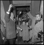 8949-2 Feestelijk uitgedoste kinderen gaan door een toegangsdeur van de in aanbouw zijnde Beneluxtunnel.