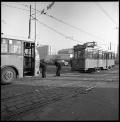 9055 Op het Stationsplein bij het Weena wordt een gestrande tram van lijn 1 weggesleept door een stadsbus.