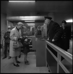 9076 Reizigers en RET-personeel bij tourniquetten en stempelautomaat in een ondergronds metrostation.