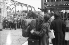 1993-5457 Militair zoent vrouw op station Delftsche Poort. De aankomst van eerste trein gerepatrieerden uit Duitsland.