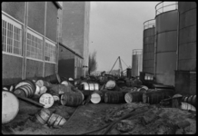 530202-6 Schade in de fabrieken van Unilever in Vlaardingen na de watersnood. Buiten liggen beschadigde vaten tussen de ...