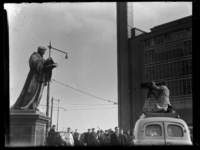 R-1923 Een cameraman van Polygoon Profilti filmt het standbeeld van Erasmus vanaf een bus. Op de achtergrond kijkt ...