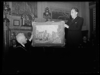 R-1949 In de Burgerzaal van het stadhuis ontvangt burgemeester P.J. Oud een schilderij van Rotterdam.