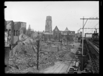 R-1958 De Laurenskerk en omringende gebouwen zijn zwaar beschadigd na het bombardement. Rechts herstellen mannen de ...