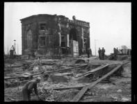 R-1959 Mannen ruimen puin na het bombardement bij het Hofplein. Op de achtergrond een zwaar beschadigde Delftsche Poort.