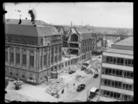 R-1983 Door een bominslag is een deel weggeslagen van het postkantoor. Linksonder de Coolsingel, rechts de Meent. ...