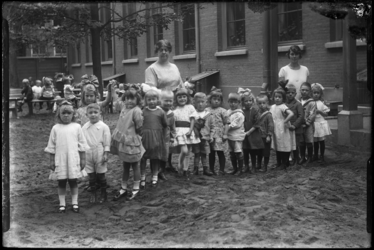 R-4921 Kleuterschool Vredenoord aan de Bethlehemstraat in Kralingen. Kinderen poseren met leidsters in een rij voor de ...