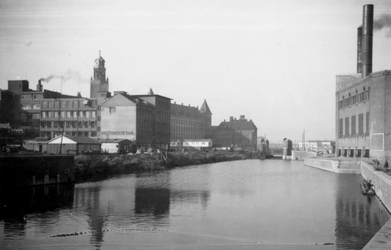 1976-2424 Gezicht op de Delftsevaart. Met rechts het gebouw voor de stadsverwarming. Links het stadhuis en verderop het ...