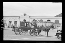 1987-2777 Een paard-en-wagen staan op de parkeerplaats voor station D.P.