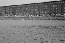 1992-3745 Veel mensen zijn aan het zwemmen in het Noorderkanaal of staan op de kade. Op de achtergrond de appartementen ...
