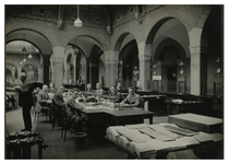XII-52-04-2 Ambtenaren van Bureau Bevolking in het stadhuis aan de Coolsingel aan het werk aan lange bureaus.