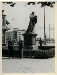 XXVI-17-00-01-02 Twee mannen poseren naast het standbeeld van Erasmus op de Coolsingel. Op de achtergrond de Blaak met ...