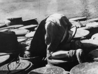 1968-290 Een kind zoekt voedselresten in vuilnisbak tijdens de hongerwinter.