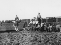 1977-3288 Een groepje bestaande uit (voornamelijk) meisjes en hun begeleiders houden zich op een atletiekbaan bezig met ...