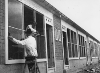 1977-3725 Glazenzetters aan het werk bij noodwoningen in het Brabants Dorp..