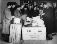 1977-3851 Hulpverlening.(Rhenen). Mensen nemen goederen in ontvangst van de HARK ( Hulp Aktie Rode Kruis).