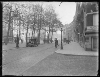 2004-2033 De Diergaardelaan met wandelaars, een personenauto, een bus en handkarren. Rechts op de hoek is een vestiging ...