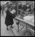 2004-2111-07 Een vrouw loopt met een net gekochte bos bloemen op de voorjaarsbloemenmarkt op de Goudsesingel.