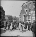 2004-2114-06 Tijdens een fietsverbod lopen fietsers met de fiets aan de hand. Rechts café C. Rijnbende. Aan de gevel ...