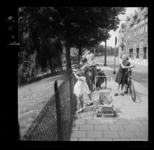 8827 Kinderen staan met kinderwagen en fietsen bij een hek langs de Bergsingel en voeren eenden.