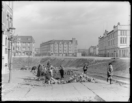 FD-3963 Kinderen spelen op een opgebroken straat bij het Heiman Dullaertplein. Rechts het gebouw van de firma Stokvis & ...