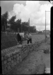 2006-15375 Arbeiders sjouwen met basaltblokken ter versterking van een talud bij de Schiedamsedijk Op de achtergond de ...