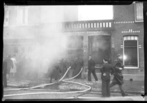2006-15413 De brandweer blust een brand in een laag blok tussen twee woningen in de Davidsstraat (20-24).