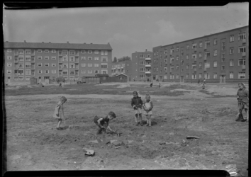 2006-15522 Kinderen vermaken zich op een braak liggend veldje achter de Schiedamseweg. Links een flatgebouw aan de ...