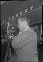 2006-15771 Een cameraman van de firma Uitenbroek kijkt voor de Bijenkorf door de lens van een Linhof filmcamera. Hij ...