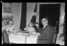 THO-1022 Fotograaf C.M. Tholens zit met zijn gezin aan tafel tijdens het kerstfeest.