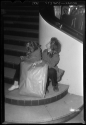 THO-1085 Met een ingepakte aankoop bij kledingzaak Esders aan de Binnenweg, wachten kinderen op de trap van de winkel.