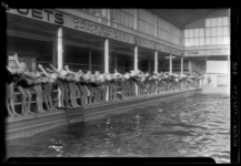 THO-1149 Tijdens een zwemles staat een rij leerlingen in duikhouding aan de rand van het zwembad. Uit een serie over ...